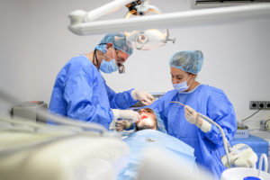 Dental Surgeon And Assistant Work Putting Dental Implant